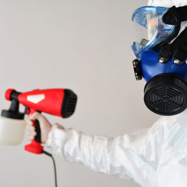 person doing mold removal with hazmat gear on